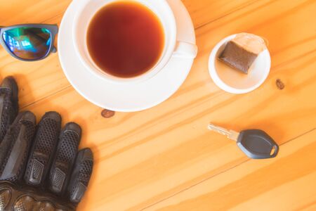 driving glove and glasses place near tea cup on the wooden tableの写真素材