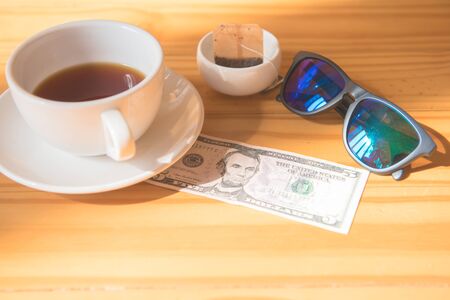 make money tip dollar or euro for travel and tea cup near on the wooden tableの写真素材