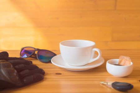 driving glove and glasses place near tea cup on the wooden tableの写真素材
