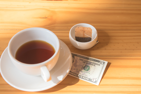 make money tip dollar or euro for travel and tea cup near on the wooden tableの写真素材