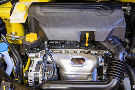 Closeup detail of new car and new engine in factory for the background.