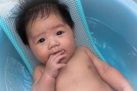 baby smiling and happy  shower in bathroom with motherの写真素材