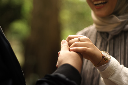 man grab his hijab woman's handの写真素材
