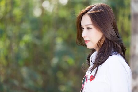 Asian woman smiling happy on sunny summer or spring day outside in parkの写真素材