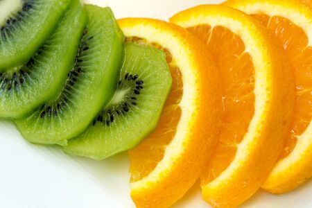 sliced Kiwi fruit and citrus Orange placed in a white dish.の写真素材