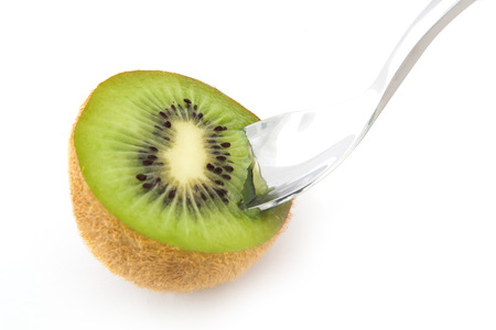 A sliced kiwi fruit, complete with spoon ready to eatの写真素材