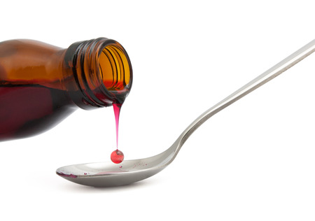 bottle with medicine and spoon isolated on whiteの写真素材