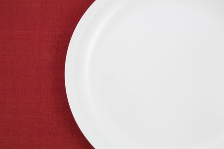empty plate on red tableclothの写真素材