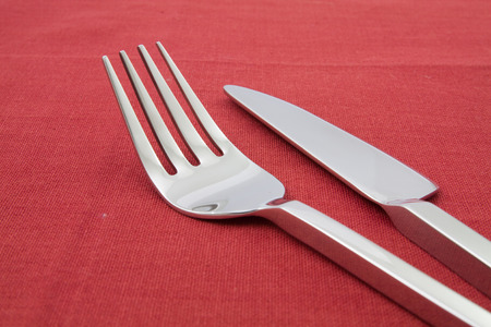 fork and knife  on red tableclothの写真素材