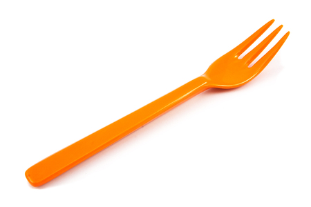 Orange plastic forks isolated on white backgroundの写真素材