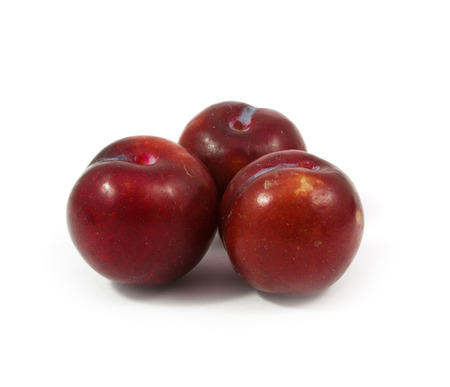 ripe purple cherry plums isolated on whiteの写真素材