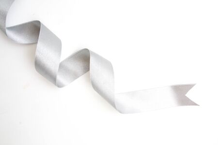 silver ribbon bow in bright silver white grey color isolated on white backgroundの写真素材