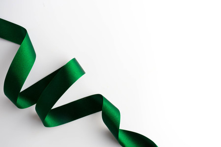 Green bow ribbon satin texture isolated on white backgroundの写真素材