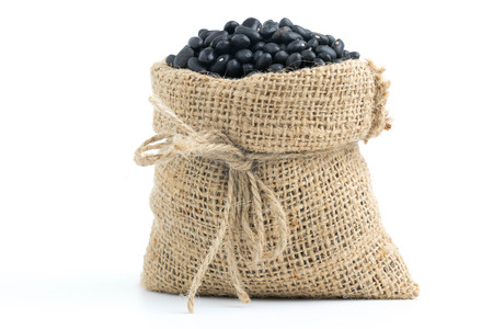black beans in canvas sack on white backgroundの写真素材