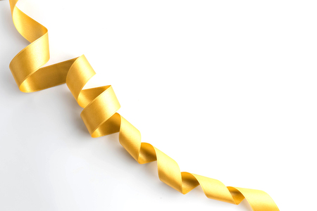 gold bow ribbon satin texture isolated on white backgroundの写真素材