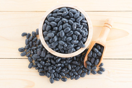 Black-beans in wood cup on sack backgroundの写真素材