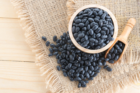 black-beans in wood cup on sack backgroundの写真素材