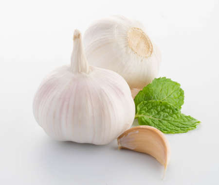 garlic with leaves of green mint isolated on whiteの写真素材