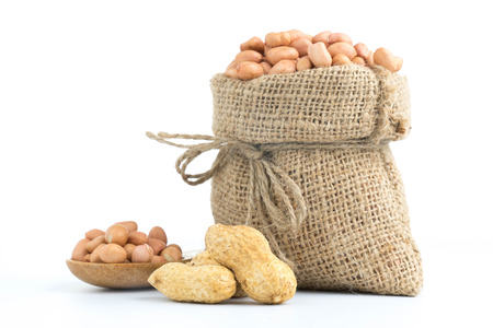 peanuts in burlap sack isolated on white backgroundの写真素材