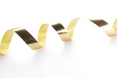 Golden ribbon roll isolated on white backgroundの写真素材