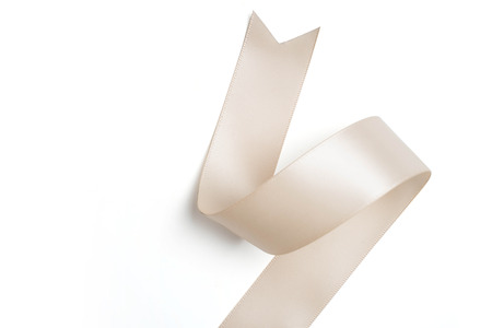 cream ribbon in roll on white backgroundの写真素材