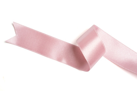 Pink ribbon in roll on whiteの写真素材