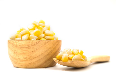 fresh sweet corn in wood bowl and spoon isolated on white backgroundの写真素材
