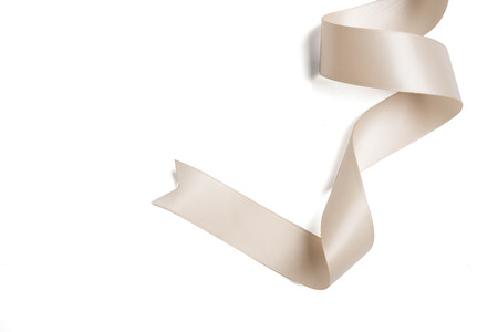 cream ribbon in roll on white backgroundの写真素材