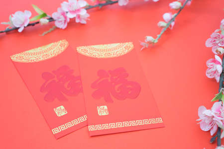 chinese new year celebration with angpao red and plum flowers on red background