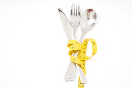 Spoon and fork with a measuring tape diet or healthy eating concept concept