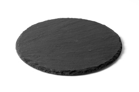 Black round stone plate isolated on white backgroundの写真素材