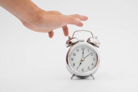 turning off an alarm clock in the morning on whiteの写真素材