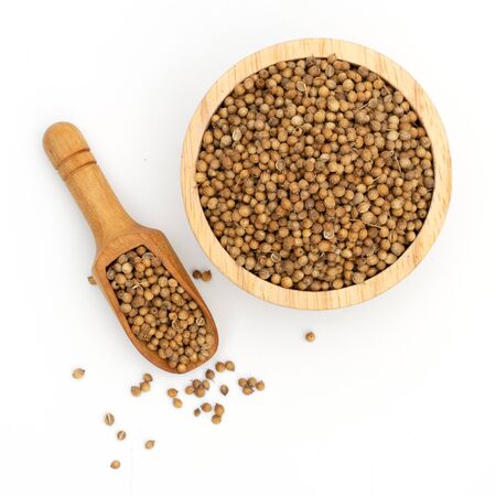 dried coriander seeds wooden bowl on white backgroundの写真素材