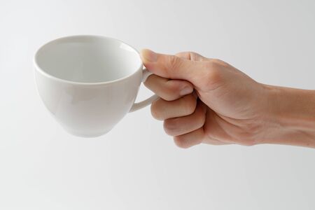 hand holding cup on white backgroundの写真素材