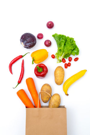 Fresh vegetables in paper bags on white backgroundの写真素材