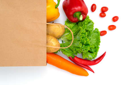 Fresh vegetables in paper bags on white backgroundの写真素材