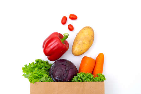 Fresh vegetables in paper bags on white backgroundの写真素材