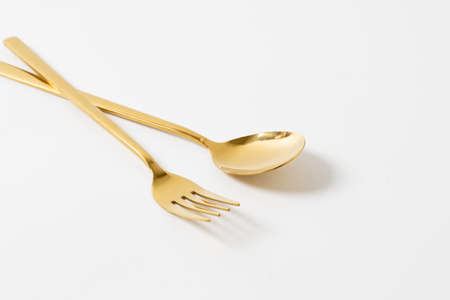 gold spoon and fork isolate on white backgroundの写真素材
