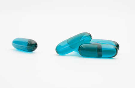 blue transparent supplement capsule isolated white backgroundの写真素材
