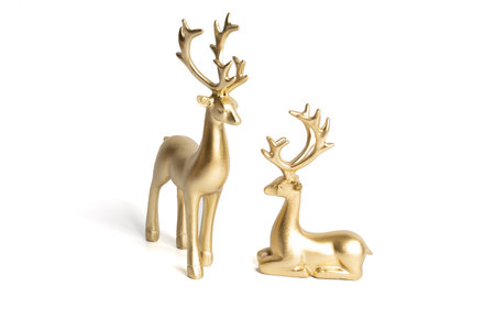 two gold ceramic statuette deer on white backgroundの写真素材