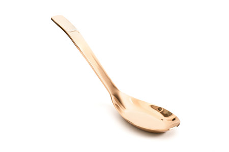 golden soup spoon top view isolated on white backgroundの写真素材