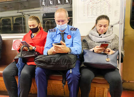 Moscow, Russia. October 10, 2020: People read on the subway. Metro in Moscow. People in protective masks.のeditorial素材