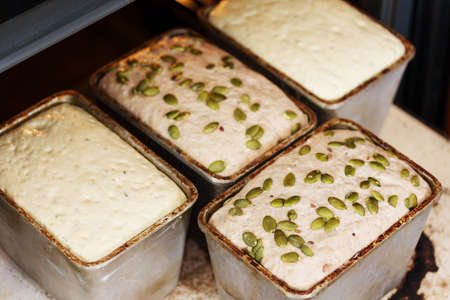 Baking homemade bread in the oven. Dough in a bread pan. Dough in a metal form for baking bread....