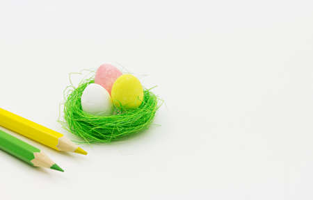 Easter white background with decorative eggs and pencils.