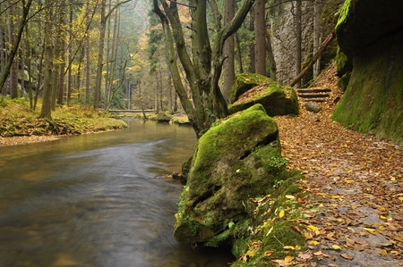 A small river flows through a wild landscape with rocksの写真素材