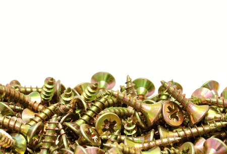 Many small golden screws on pure white backgroundの写真素材