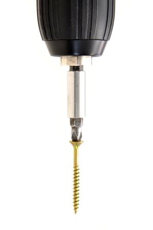 Screwing the screw using a power drill on a white backgroundの写真素材
