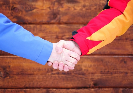 Business handshake before the new brown wooden buildingの写真素材