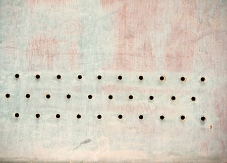 Old and rusty perforated sheet painted a light colorの写真素材