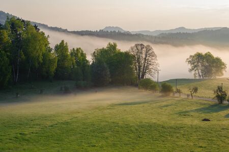Autumn landscape with hills and forests in sunny morning mistの写真素材